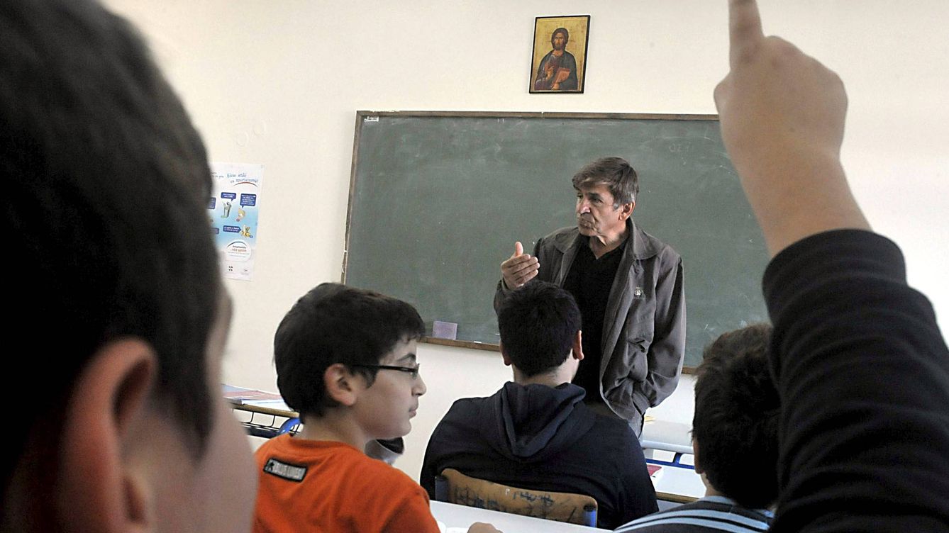 Foto: Un profesor imparte una asignatura en un aula con una imagen de Jesucristo (EFE)