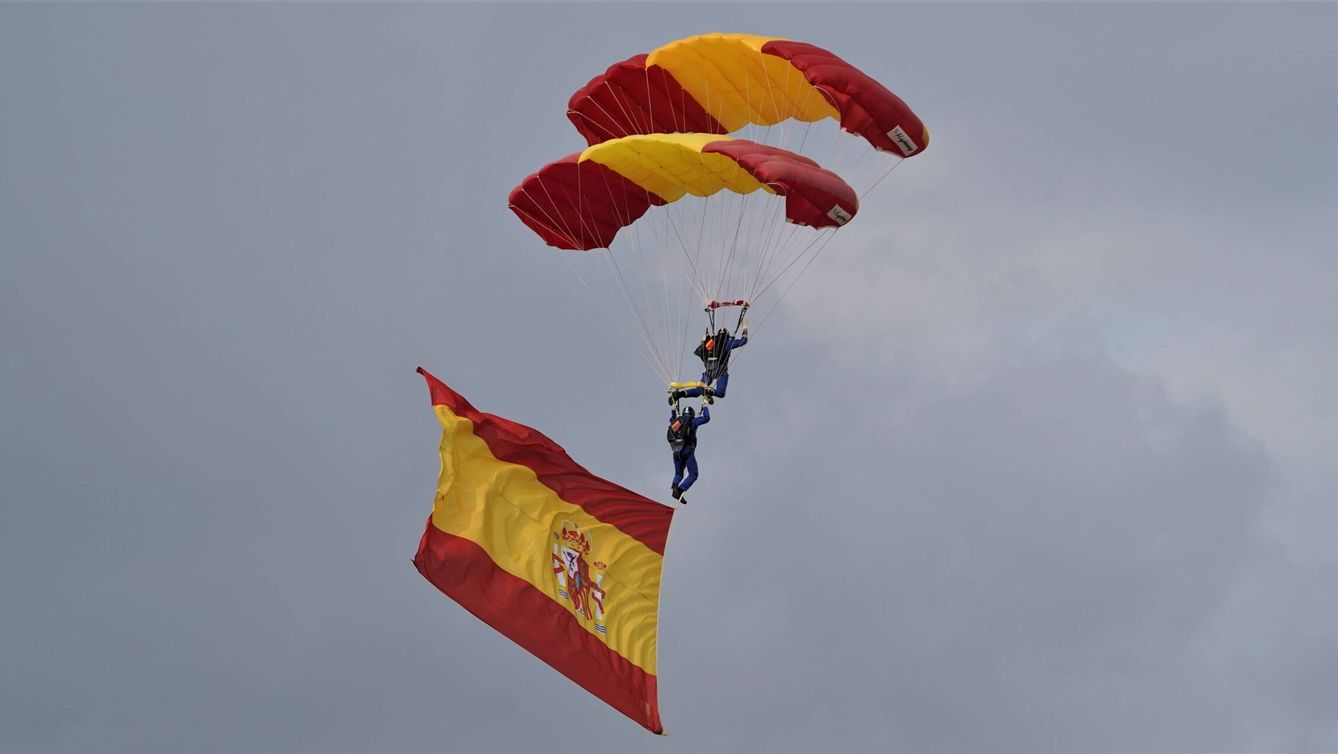 Las siempre espectaculares exhibiciones de la Patrulla Acrobática Paracaidista del Ejército del Aire y del Espacio, en este caso dos paracaidistas descienden mientras despliegan la bandera nacional. (Ángel del Peso)