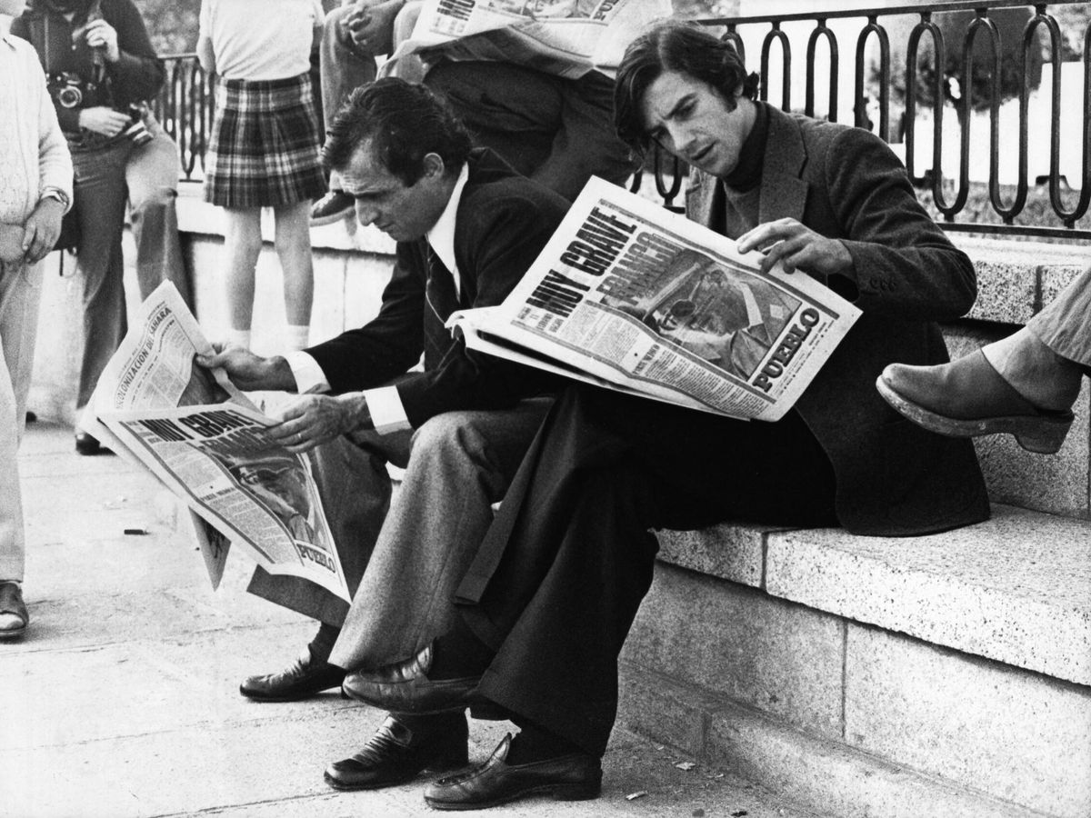 Foto: Un par de personas leen el diario 'Pueblo' unas semanas antes de la muerte de Franco en 1975. (Getty/Hulton Archive/Keystone)