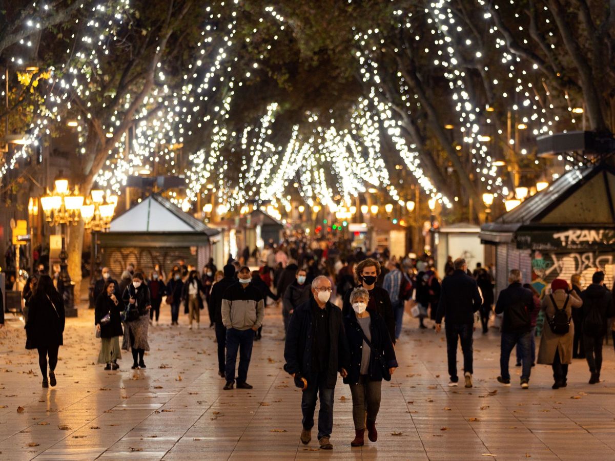 Foto: Ciudadanos paseando entre luces de Navidad. (EFE)