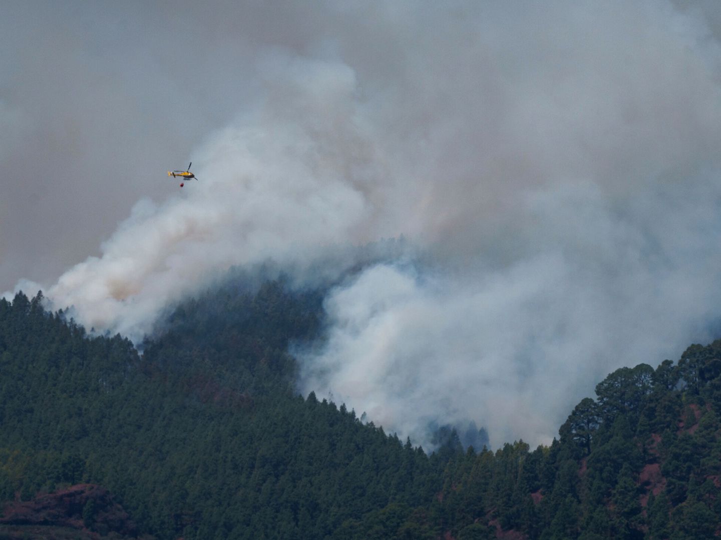 Un helicóptero trabaja en la extinción del incendio forestal en los altos de Güímar. (EFE/Ramón de La Rocha) 