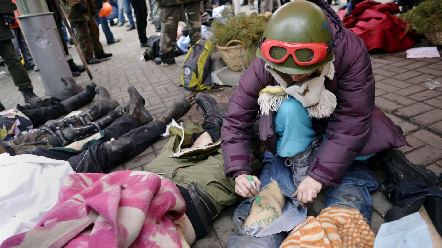Un opositor identifica cadáveres durante los disturbios en Kiev (Reuters).