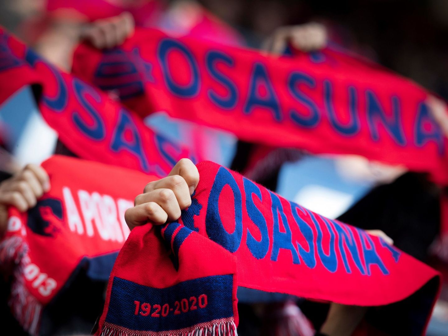 Aficionados de Osasuna muestran las bufandas del centenario del club. (EFE)