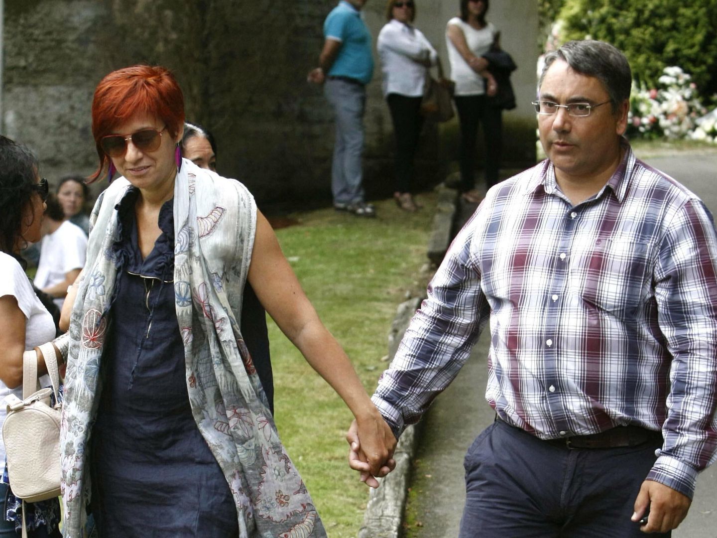 Sandra Ortega Mera, con su marido, en el entierro. (EFE)