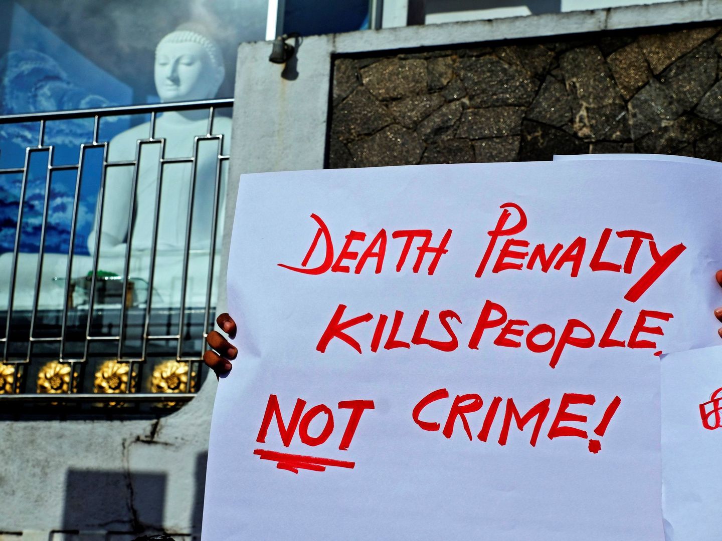 'Colectivo contra la Pena de Muerte' sostiene una pancarta en la que se lee 'La pena de muerte mata gente, no el crimen' durante una protesta. (Efe)