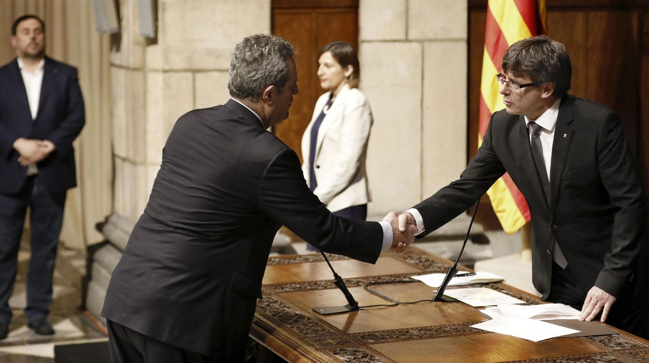 El nuevo 'conseller' de Interior, Joaquim Forn (2i), saluda al presidente de la Generalitat, Carles Puigdemont (d). (EFE)