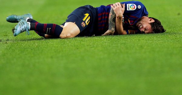 Foto: Messi en el suelo tras la caída en la que se dañó el codo derecho. (EFE)