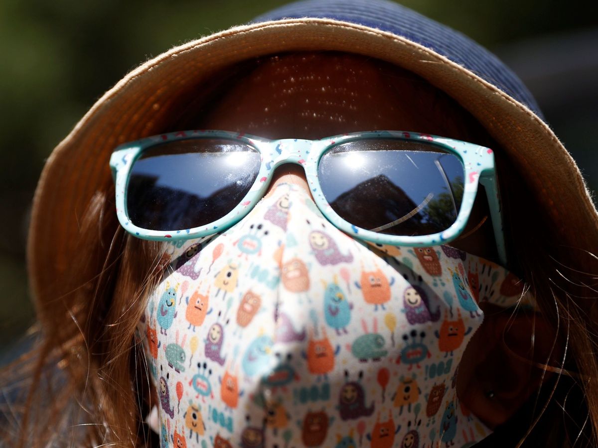 Foto: Una niña se protege del sol con sombrero y gafas. (EFE)