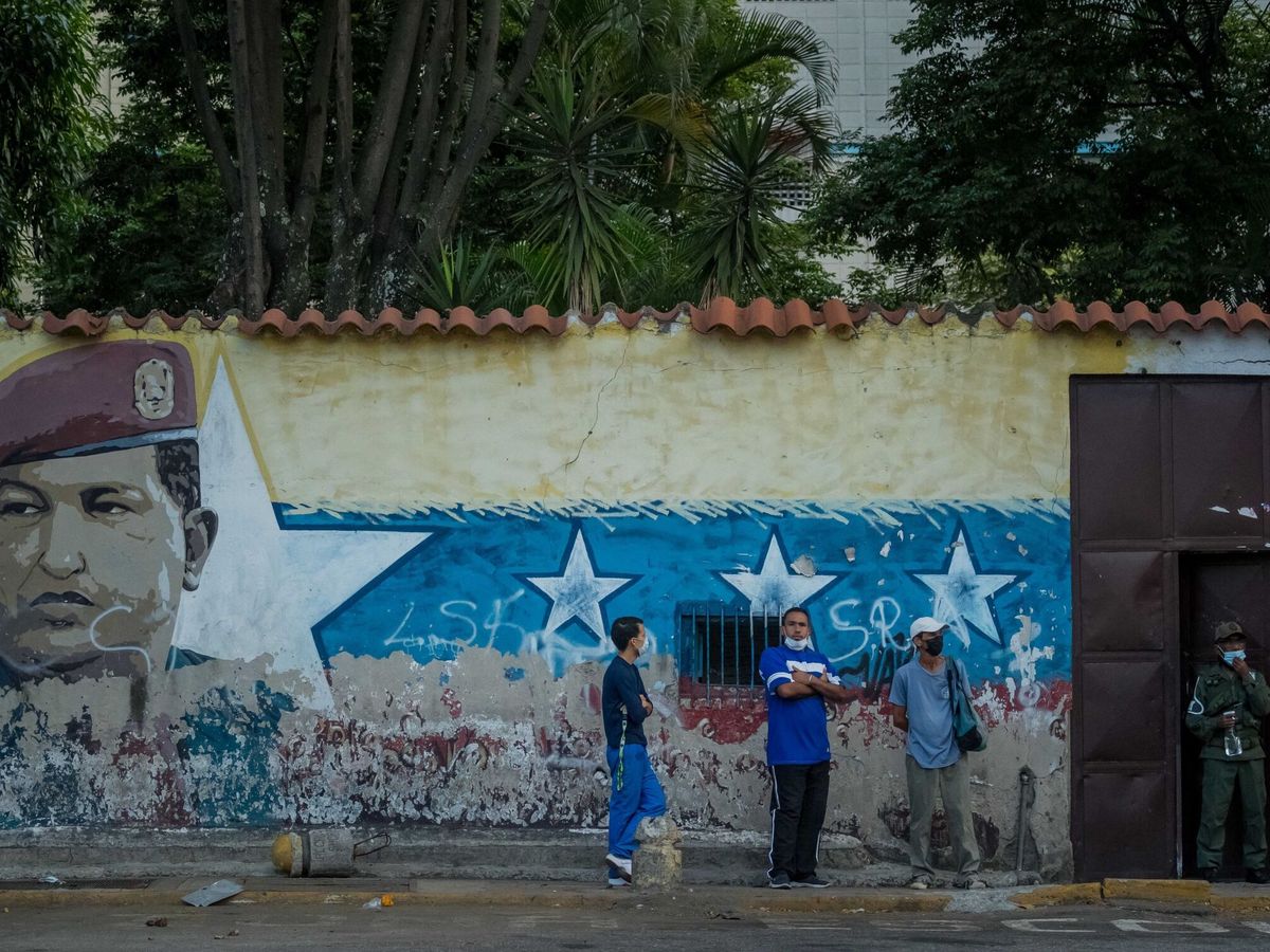 Foto: Tres personas, en la cola de votación en Caracas. (EFE/Miguel Gutiérrez)