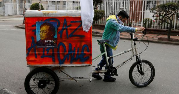 Foto: Un hombre arrastra un triciclo en el que transporta propaganda electoral del candidato Gustavo Petro en Bogotá, el 21 de mayo de 2018. (Reuters)