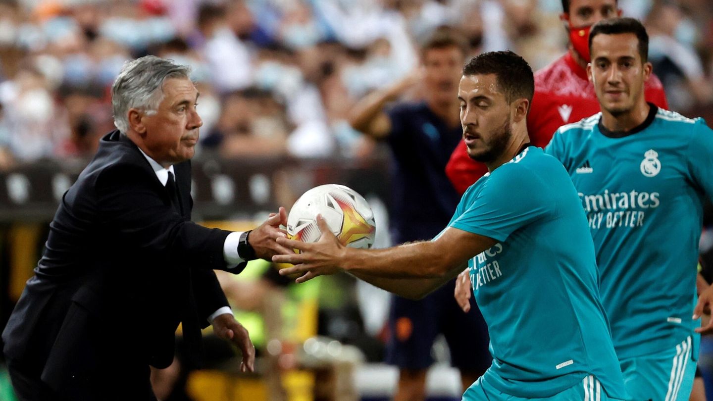 Ancelotti entrega una pelota al belga para que saque de banda. (EFE)