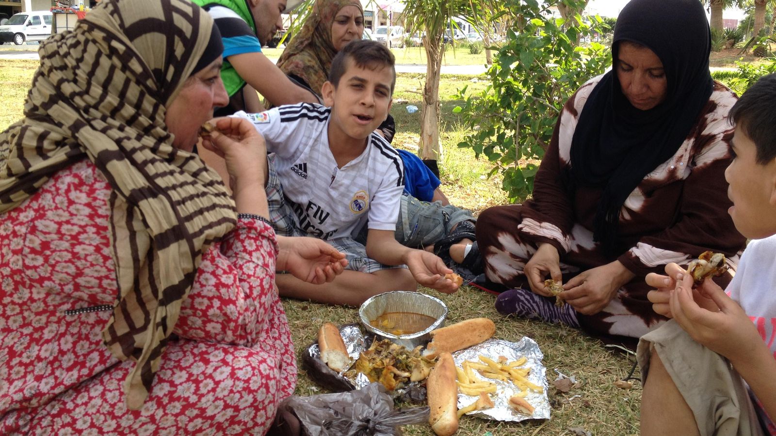Foto: Fátima toma pollo asado comprado por una marroquí junto a sus amiga y familia siria. (A. Rivera)