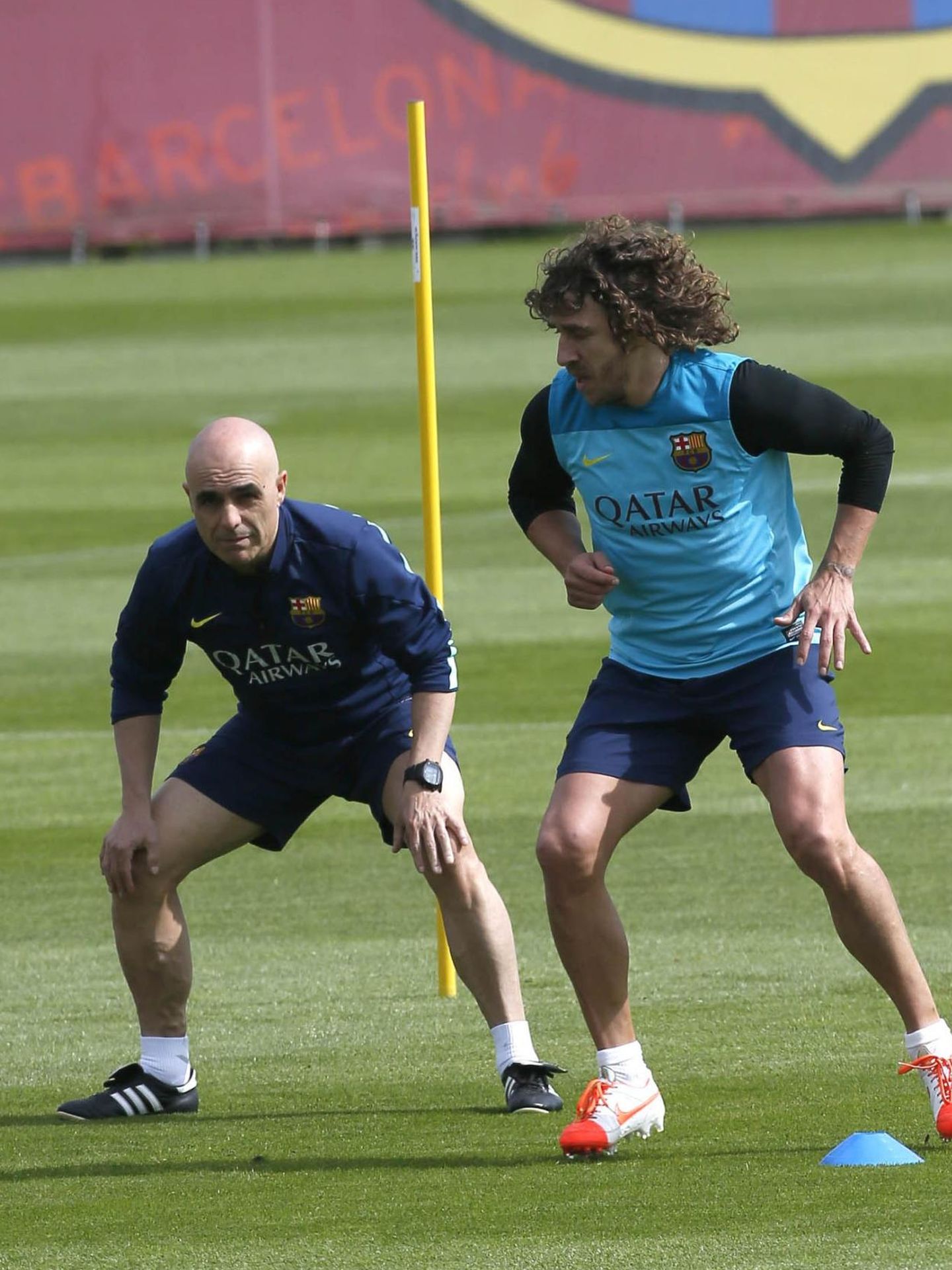 Barcelona's captain carles puyol runs beside his assistant during a training session at ciutat esportiva joan gamper training camp, near barcelona