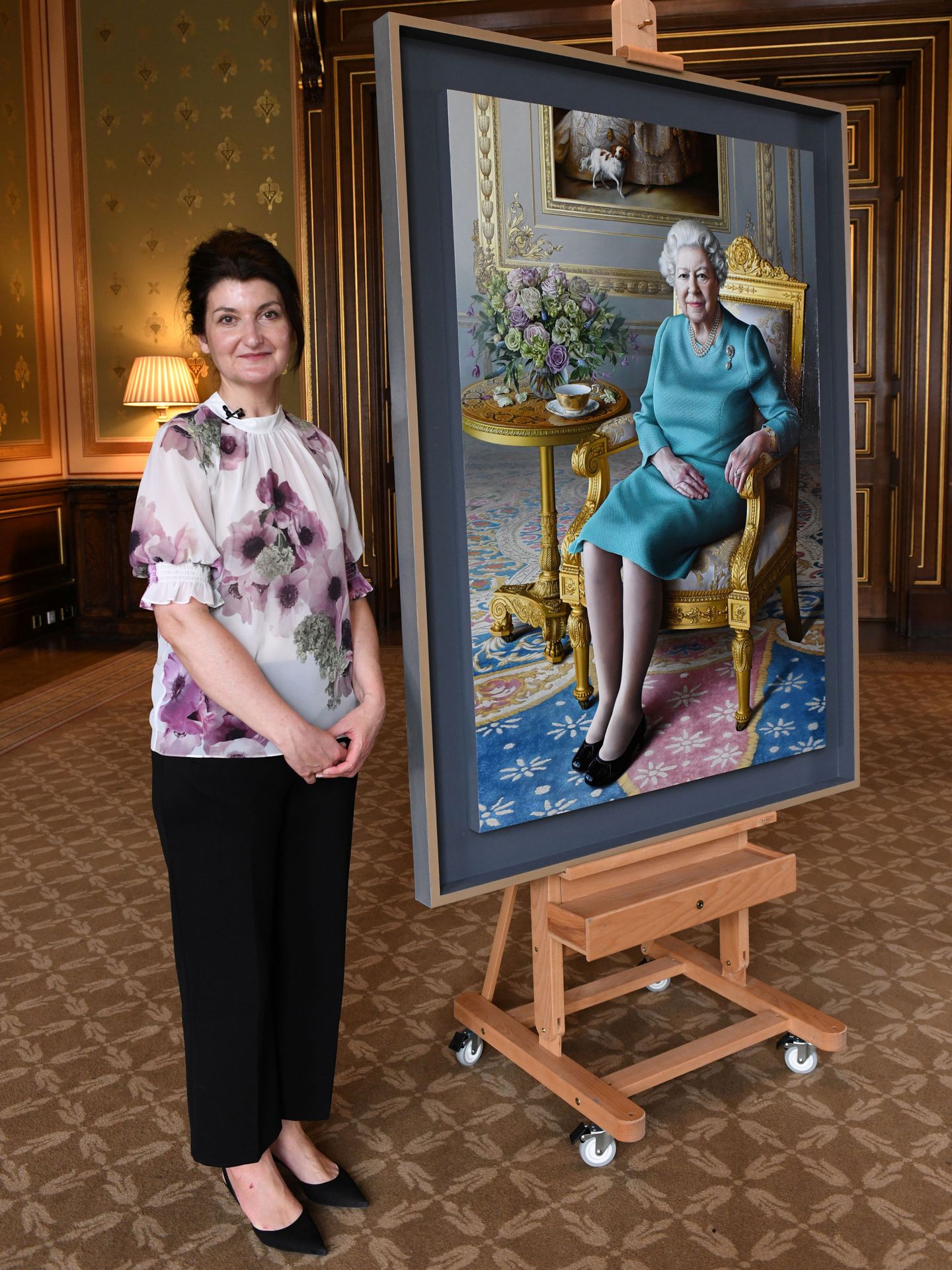 Miriam Escofet, posando junto al retrato de Isabel II. (Reuters)