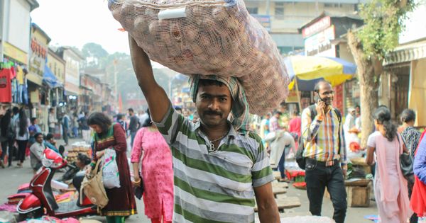 Foto: Un campesino indio con un saco de cebollas en la cabeza.