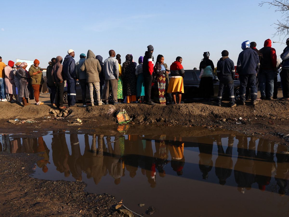 Foto: Varias personas observan el lugar donde se ha producido la fuga de gas. (Reuters/Siphiwe Sibeko)