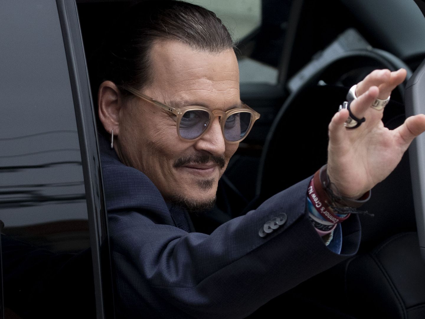 El actor estadounidense Johnny Depp saluda a sus fans tras una vista del juicio contra Amber Heard. (EFE)