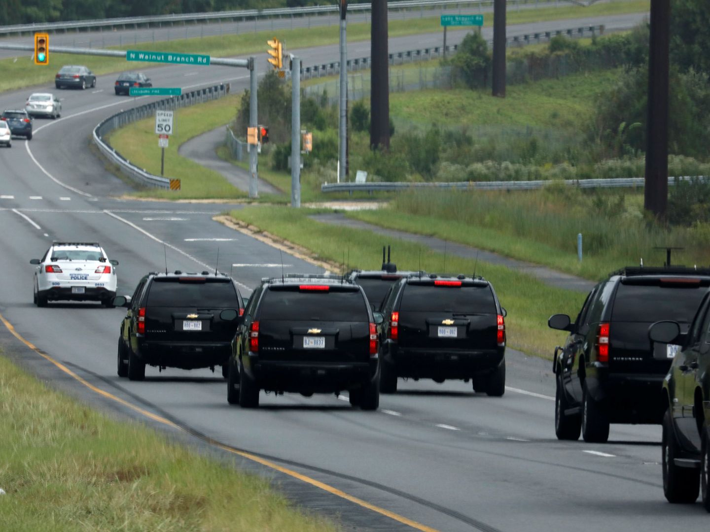 Los coches oficiales del presidente Donald Trump, dirigiéndose al Club de Golf Nacional de Sterling Virginia mientras se celebraba el funeral. (Reuters) 