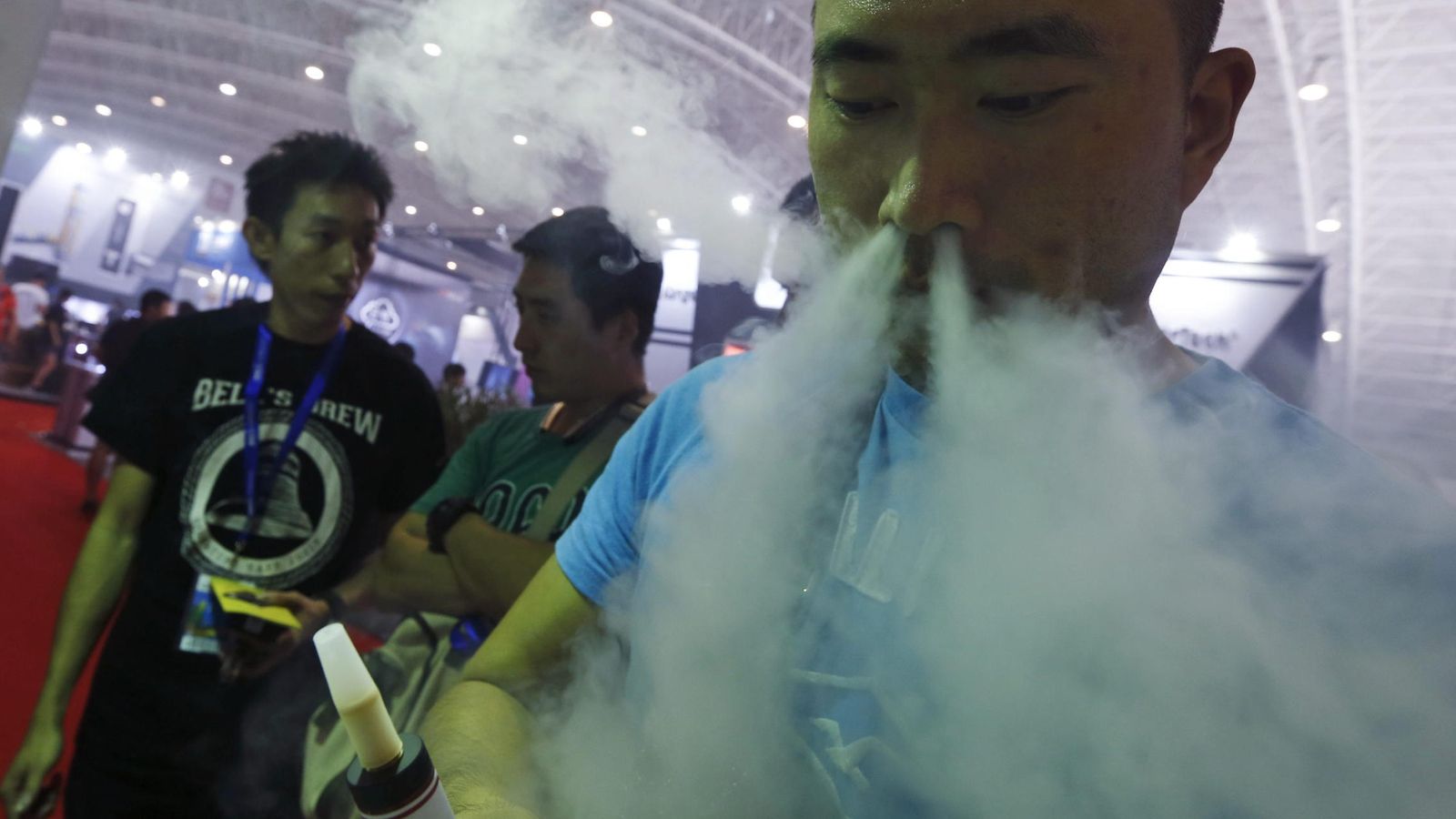 Foto: Un visitante prueba un cigarrillo electrónico en un stand de la feria "Vape China Expo" del cigarrillo electrónico