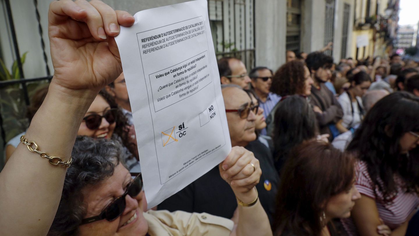Varias personas a favor del referéndum soberanista en Cataluña asisten al acto. (EFE)