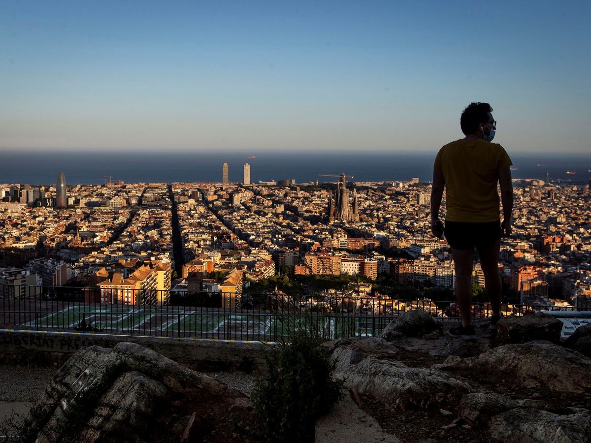Foto: Un hombre observa la ciudad desde la montaña de El Carmelo, en Barcelona. (EFE/Enric Fontcuberta)