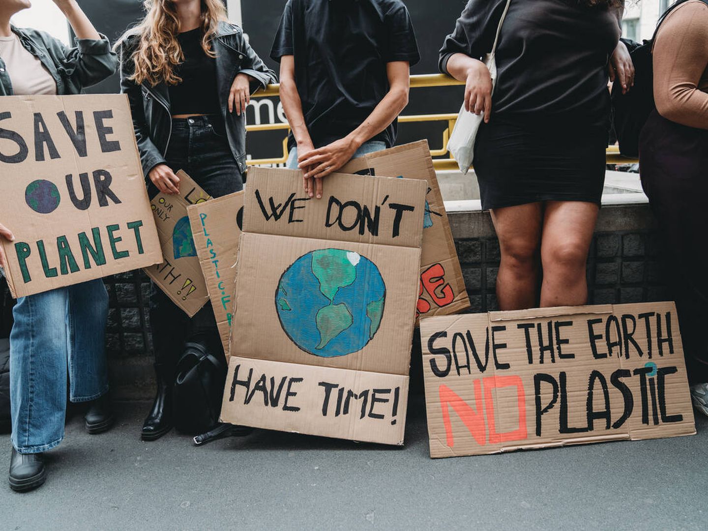 La gente sostiene pancartas mientras van a una manifestación contra el cambio climático - Foto de stock