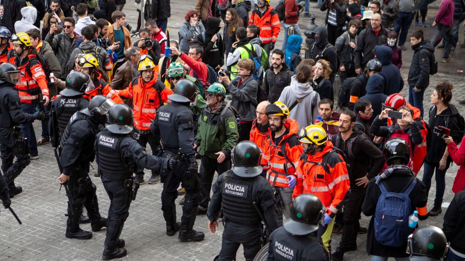 Foto: Bomberos montan un cordón entre 'mossos' y manifestantes para evitar incidentes el pasado 21 de diciembre. (EFE)