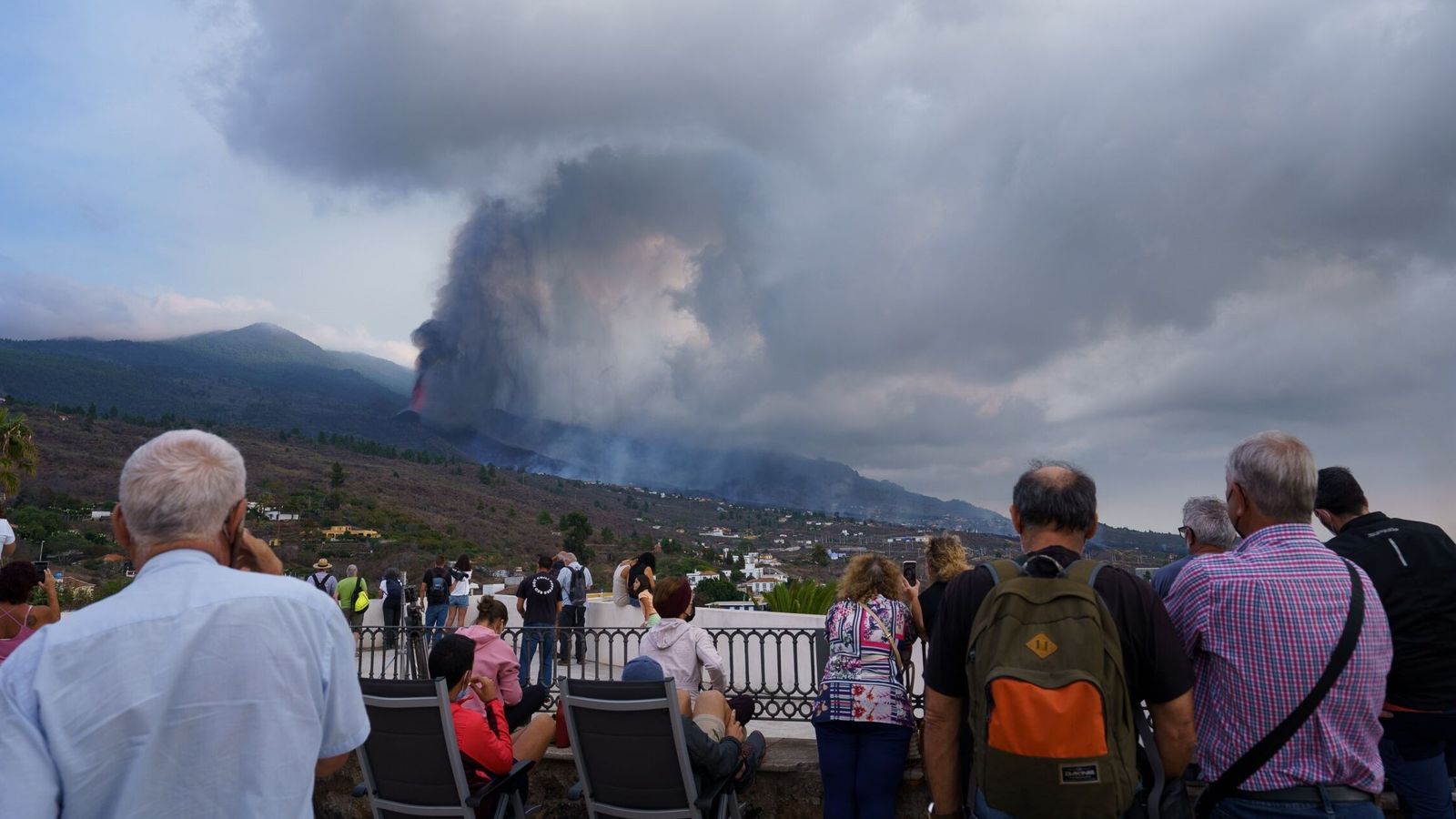 Numerosas personas observan desde un mirador de la localidad de Tajuya, en el municipio de El Paso, la evolución del volcán. (EFE)