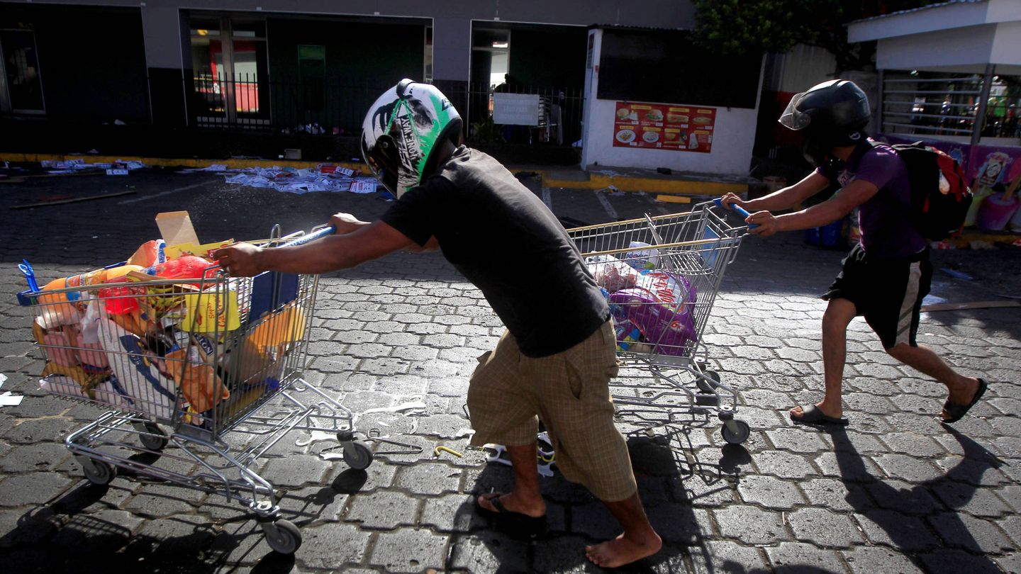 Nicaraguenses con bienes robados de una tienda durante saqueos en Managua, Nicaragua. (Reuters)