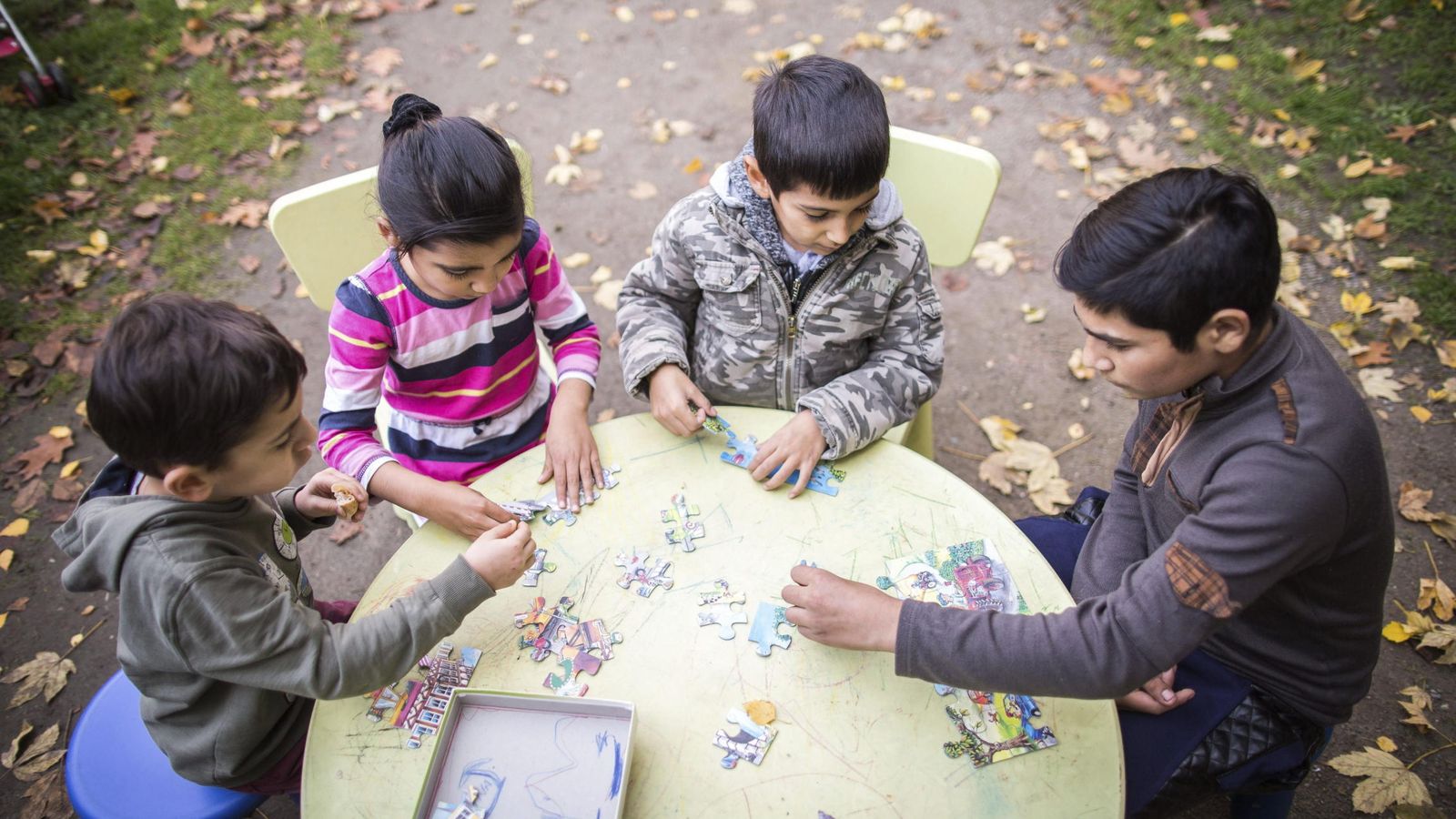 Foto: Un grupo de niños, alrededor de una mesa mientras juegan. (EFE)