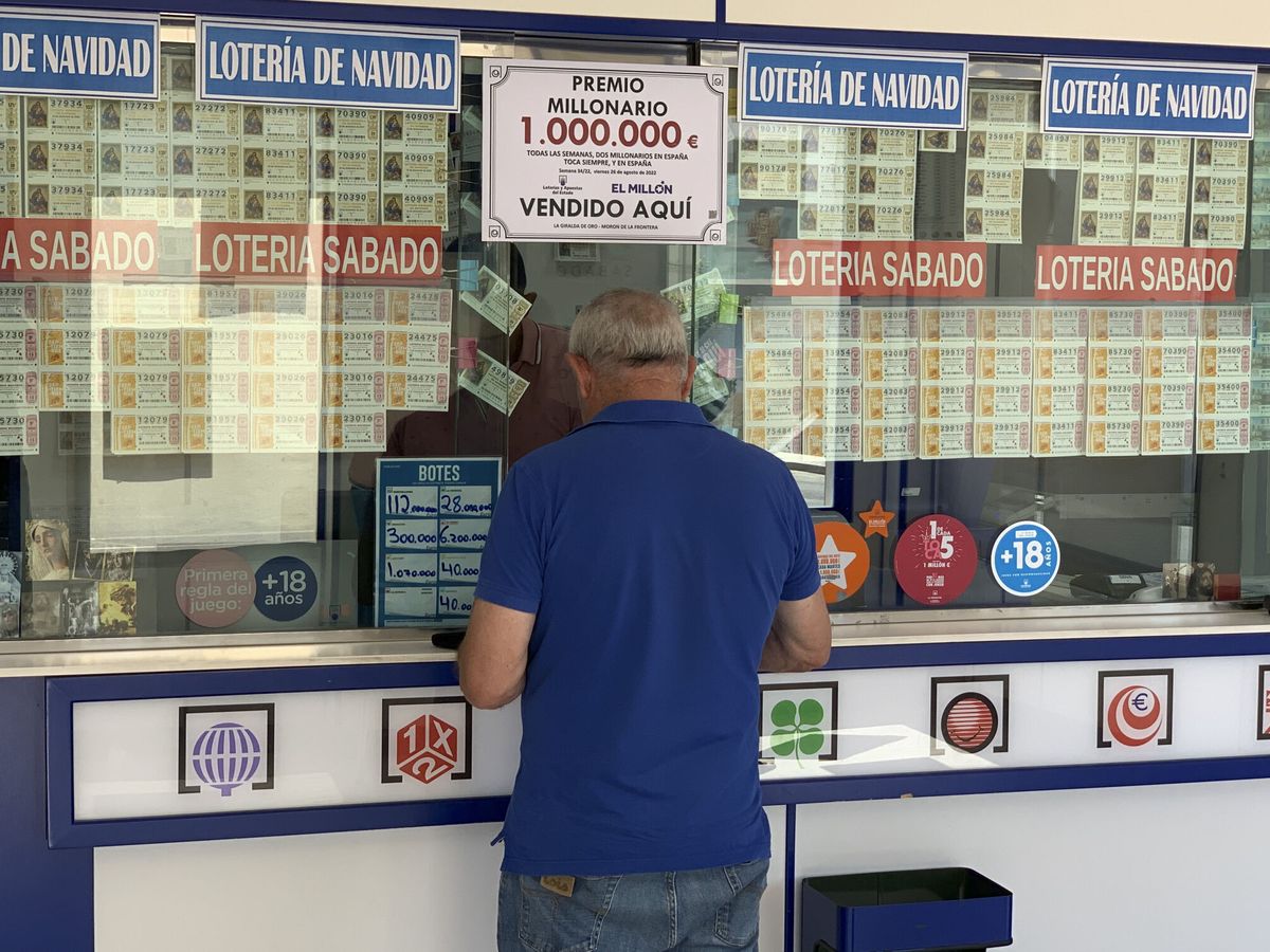 Foto: Un hombre adquiere un boleto de Lotería en la administración de 'La Giralda de Oro', en Morón de la Frontera (Sevilla). (EFE/Fermín Cabanillas)
