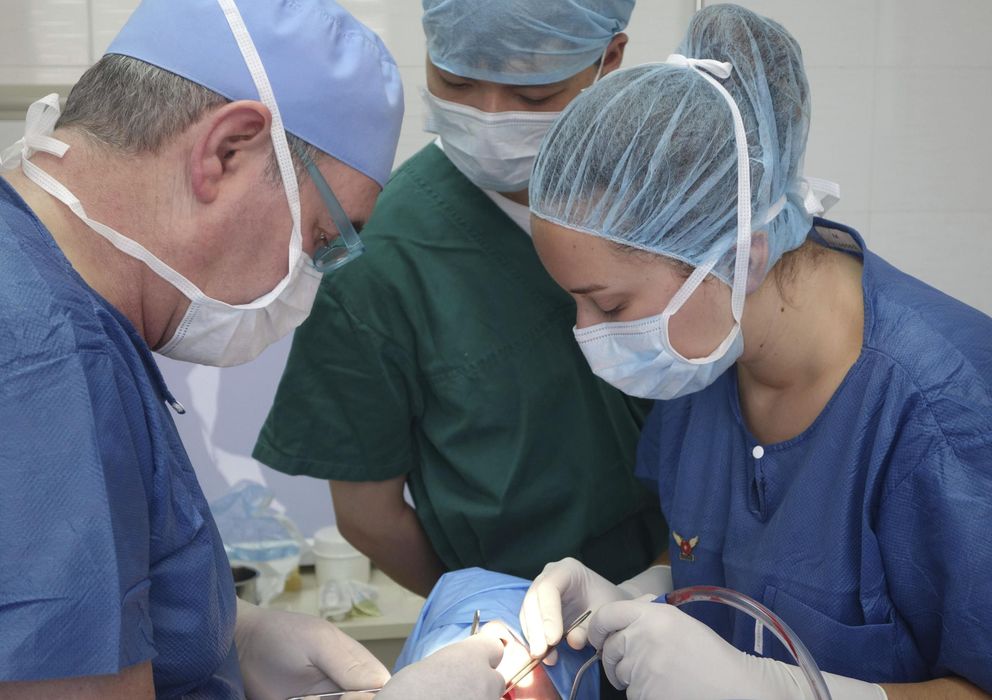 Foto: Tres cirujanos durante una operación (EFE)