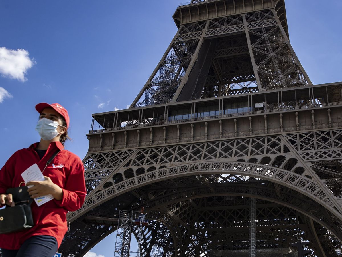 Foto: Mujer con mascarilla frente a la Torre Eiffel. (Reuters)