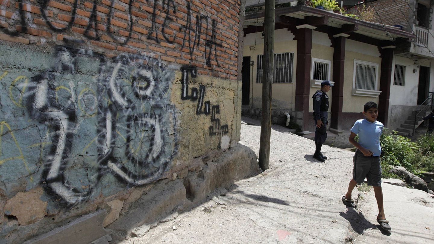 Un niño pasa ante una pintada de la Mara 18 en un barrio de Tegucigalpa. (Reuters) 