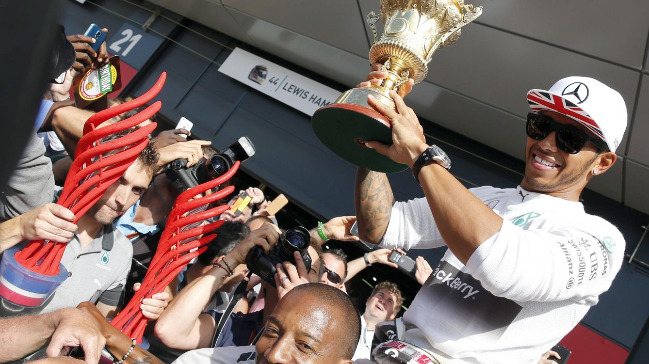 Foto: Lewis Hamilton celebrando su triunfo el año pasado, ya con su trofeo de oro, y no el que recogió en el podio, rojo (Efe)