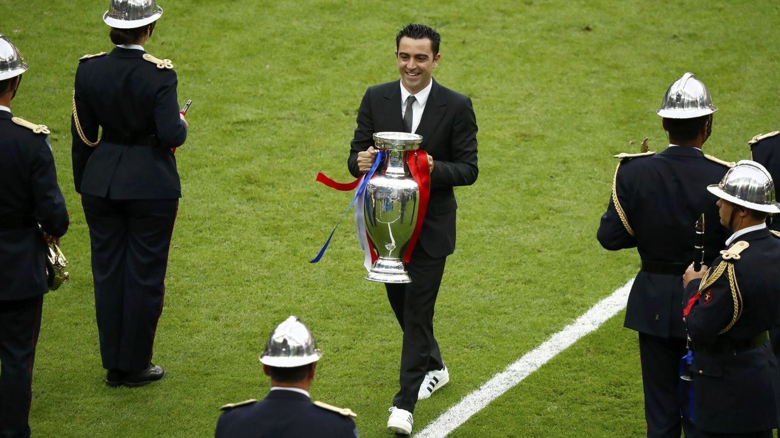 Foto: Xavi, en el momento de entregar la Eurocopa que estaba en posesión de España. (Reuters)