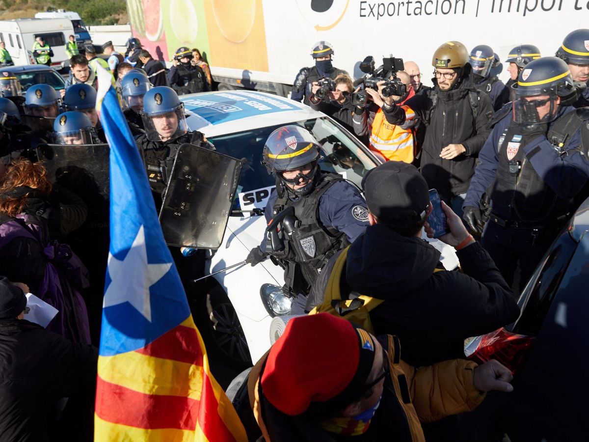 Foto: Gendarmes franceses tratan de desbloquear el corte de la autopista que enlaza España y Francia. (EFE)