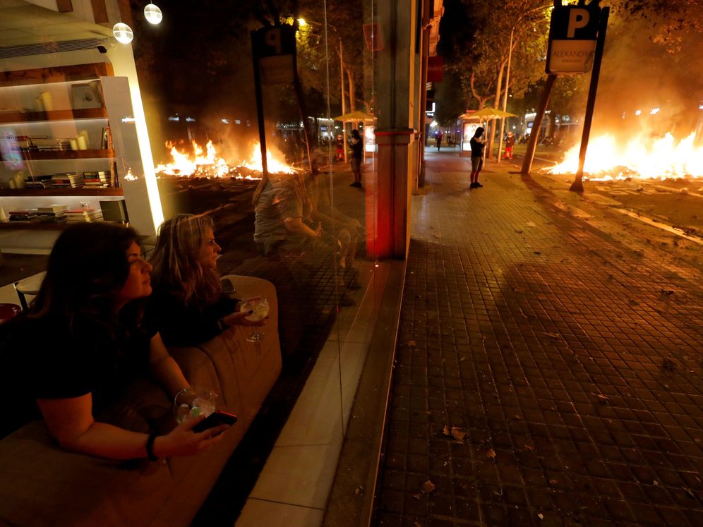 Foto: Dos mujeres son testigos de los disturbios en Barcelona desde un bar (REUTERS/Juan Medina)
