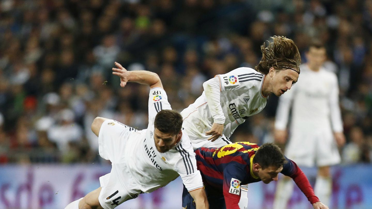 Barcelona's messi and real madrid's alonso and modric challenge for ball during la liga's second 'clasico' soccer match of the season in madrid