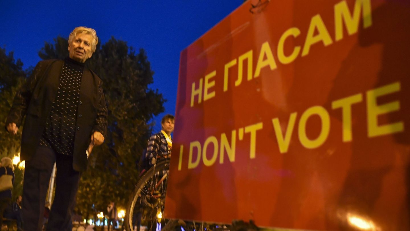 Una mujer pasa junto a una pancarta que pide el boicot en el referéndum, frente al Parlamento en Skopje, el 27 de septiembre de 2018. (EFE)