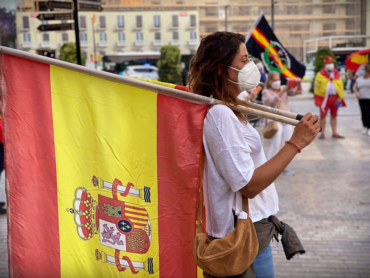 Foto: Una mujer porta la bandera de España en la concentración de la calle Larios de Málaga (Agustín Rivera).