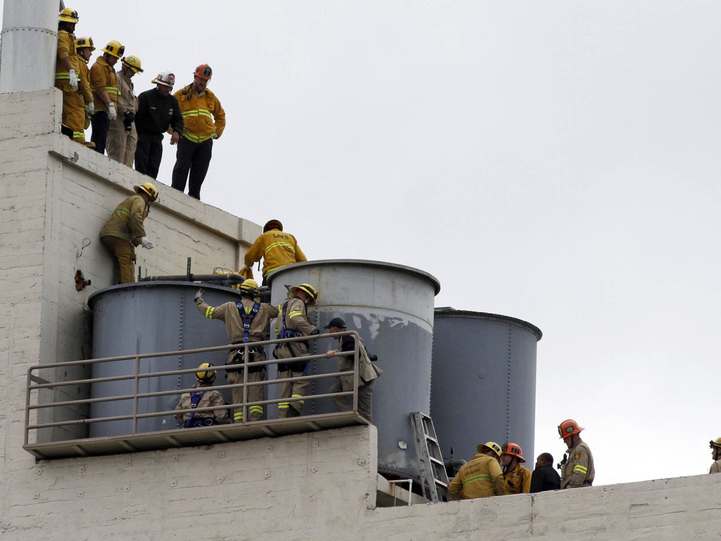 Los bomberos tratan de extraer el cadáver del depósito del agua. (Reuters)