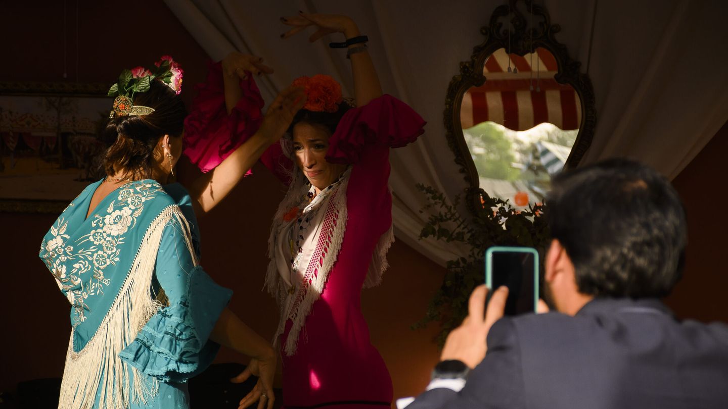 Dos mujeres bailan sevillanas en una caseta en la Feria de Abril de Sevilla (EFE/  Raúl Caro)