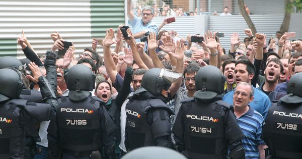 Foto: Agentes de la Policía Nacional forman un cordón policial en el exterior del IES Tarragona el pasado 1 de octubre. (EFE)