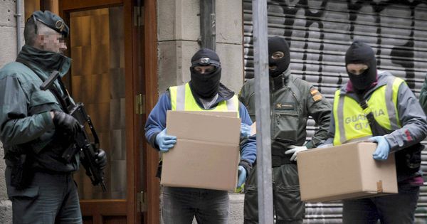 Foto: Agentes de la Guardia Civil sacan material de un inmueble tras la detención de varios etarras. (EFE)