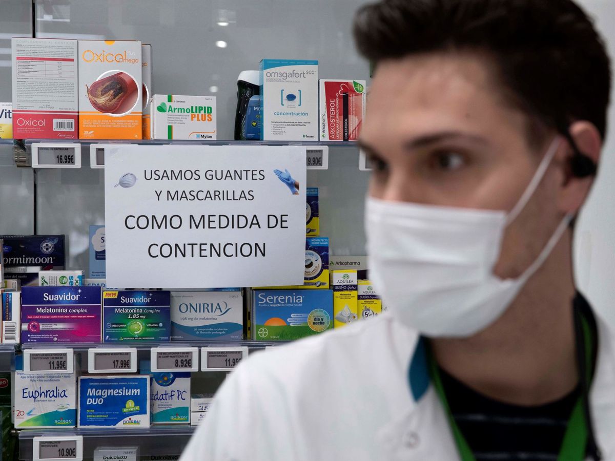 Foto: Un empleado de una farmacia con mascarilla para protegerse del coronavirus. (EFE)
