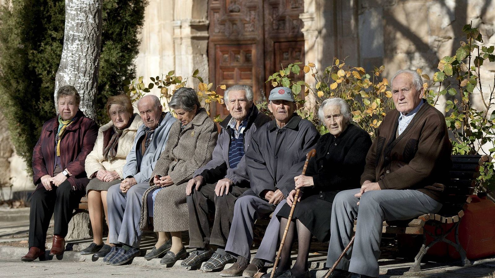 Foto: Varios ancianos toman el sol en unos bancos de Olmeda de la Cuesta, Cuenca, en una foto de archivo. (EFE)