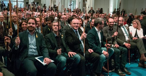 Foto: Varios alcaldes saludan al expresidente de la Generalitat catalana Carles Puigdemont (fuera de la imagen), durante el acto que 200 alcaldes independentistas celebraron en Bruselas. (EFE)
