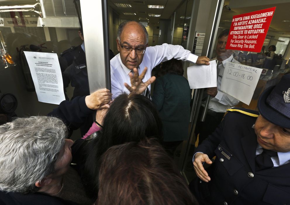 Foto: Un empleado del Banco Popular (Laiki) intenta calmar a un grupo de ahorradores en marzo (Reuters).