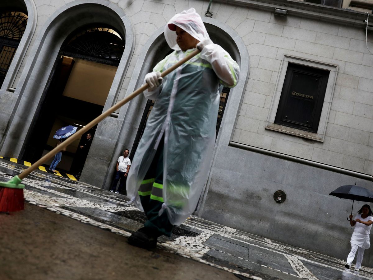 Foto: Un hombre limpiando la calle delante de la bolsa de Sao Paulo (Brasil). (Reuters)